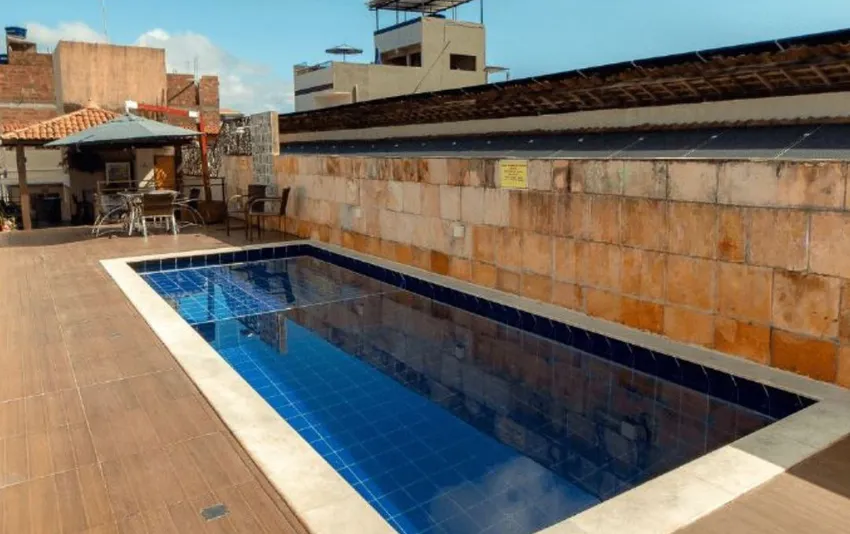 Foto de piscina retangular em área externa, com mesas ao fundo