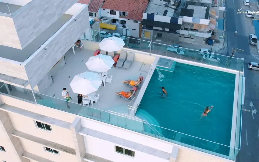 Foto com vista aérea da piscina do ultimo andar e avenida no fundo