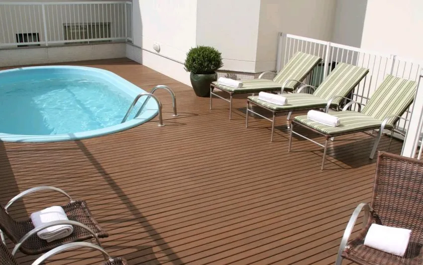 Foto de uma piscina em um deck de madeira com espreguiçadeiras