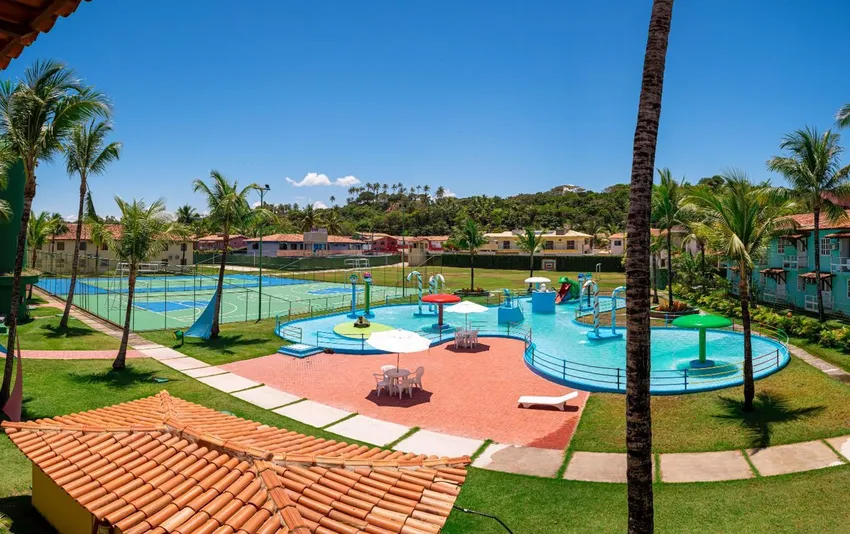 Foto da área externa de um resort com uma piscina infantil equipada com escorregador
