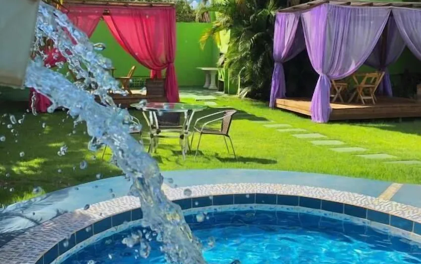 Foto da piscina com jardim e áreas de descanso ao redor