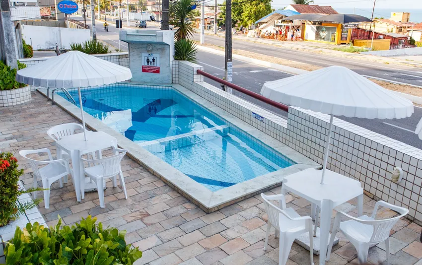 Foto da piscina vista por outro ângulo, mostrando parte da área externa ao redor e o espaço de lazer
