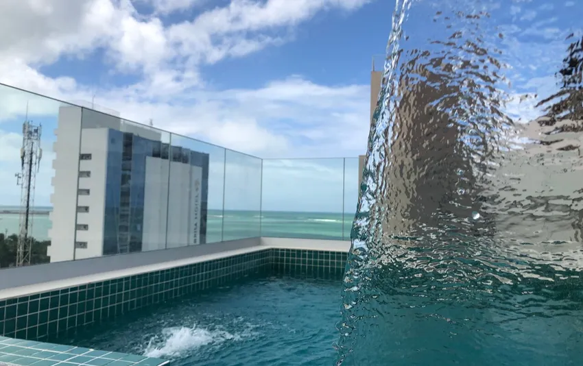 Foto da piscina com catarata e vista para o mar