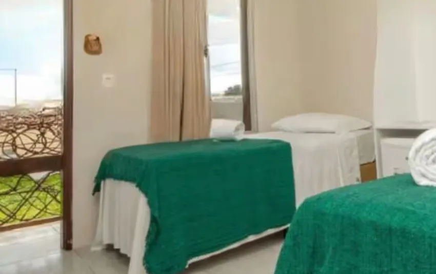 Foto de quarto com duas camas de solteiro e varanda