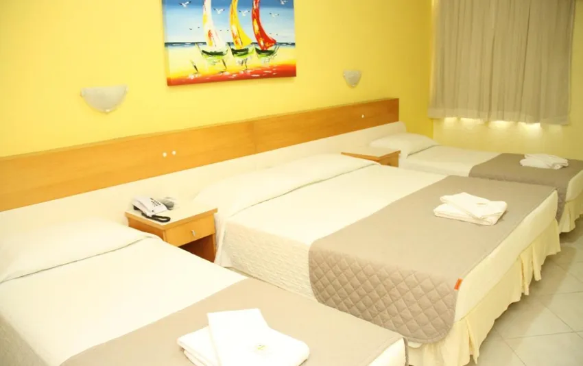 Foto de um quarto com uma cama de casal e duas camas de solteiro