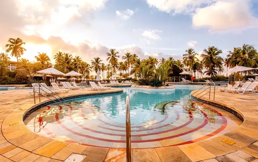 Foto da piscina e arvores no pôr do sol